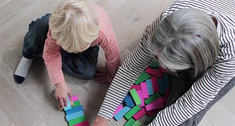 Grandma and child playing with blocks on the floor