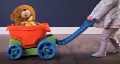Shaw - child pushing toy across hardwood